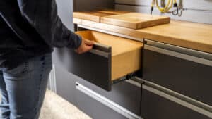 a man opens a drawer in his custom garage storage system
